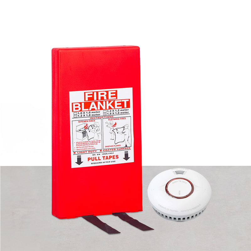 A red fire blanket with a label that says 'FIRE BLANKET' and a white smoke detector with a round, white cover next to it.