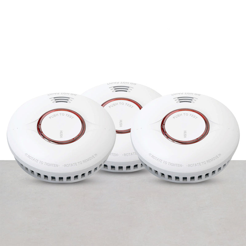 A set of three white round smoke detectors with red circles in the center, arranged on a neutral background.